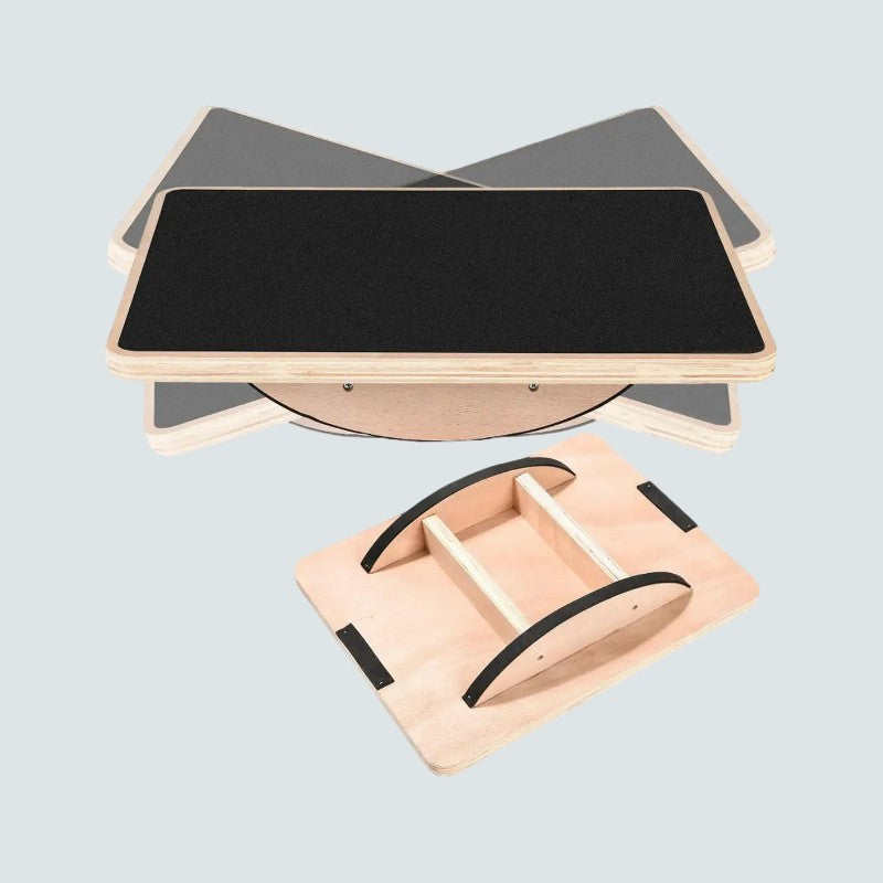 Wooden balance board with black surface on a light gray background
