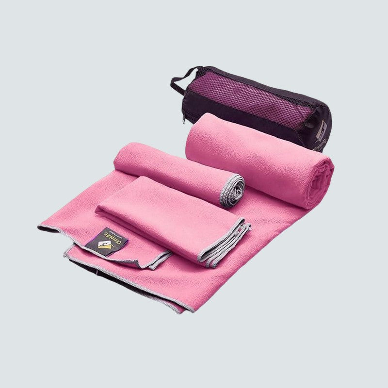 Pink cooling towel set with a black mesh pouch on a light gray background