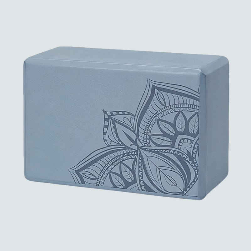 Gray yoga block with a floral design on a light gray background