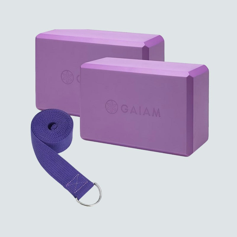 Purple yoga blocks and strap with Gaiam branding on a light gray background