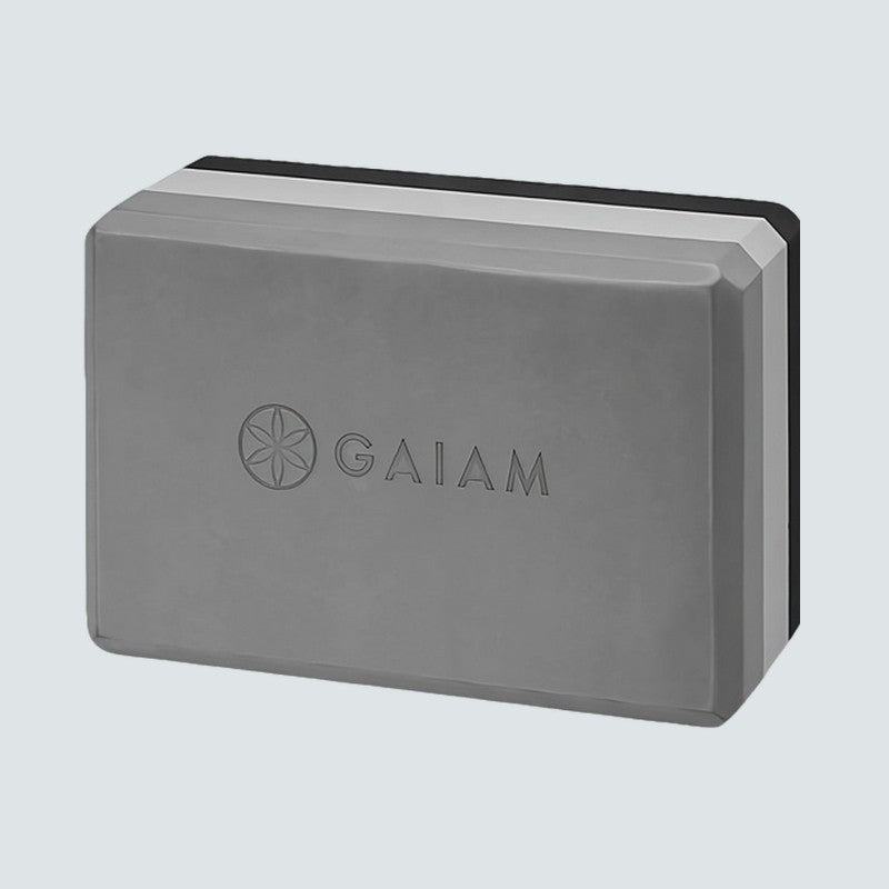 Gray yoga block with Gaiam logo on a light gray background